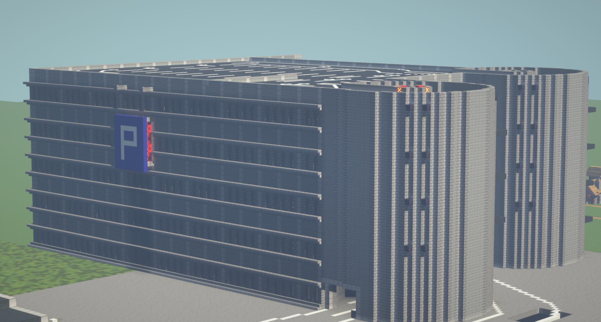 The picture shows a large parking garage on a sunny day. The multi-storey building with a gray facade and many windows dominates most of the picture. In front of the parking garage is a parking lot and a street. A blue sign with a white “P” marks the parking garage, and a parking deck can be seen on the roof.